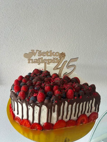 Torta s čokoládovým dripom, malinami, čučoriedkami a jahodami so zápichom k 45. narodeninám